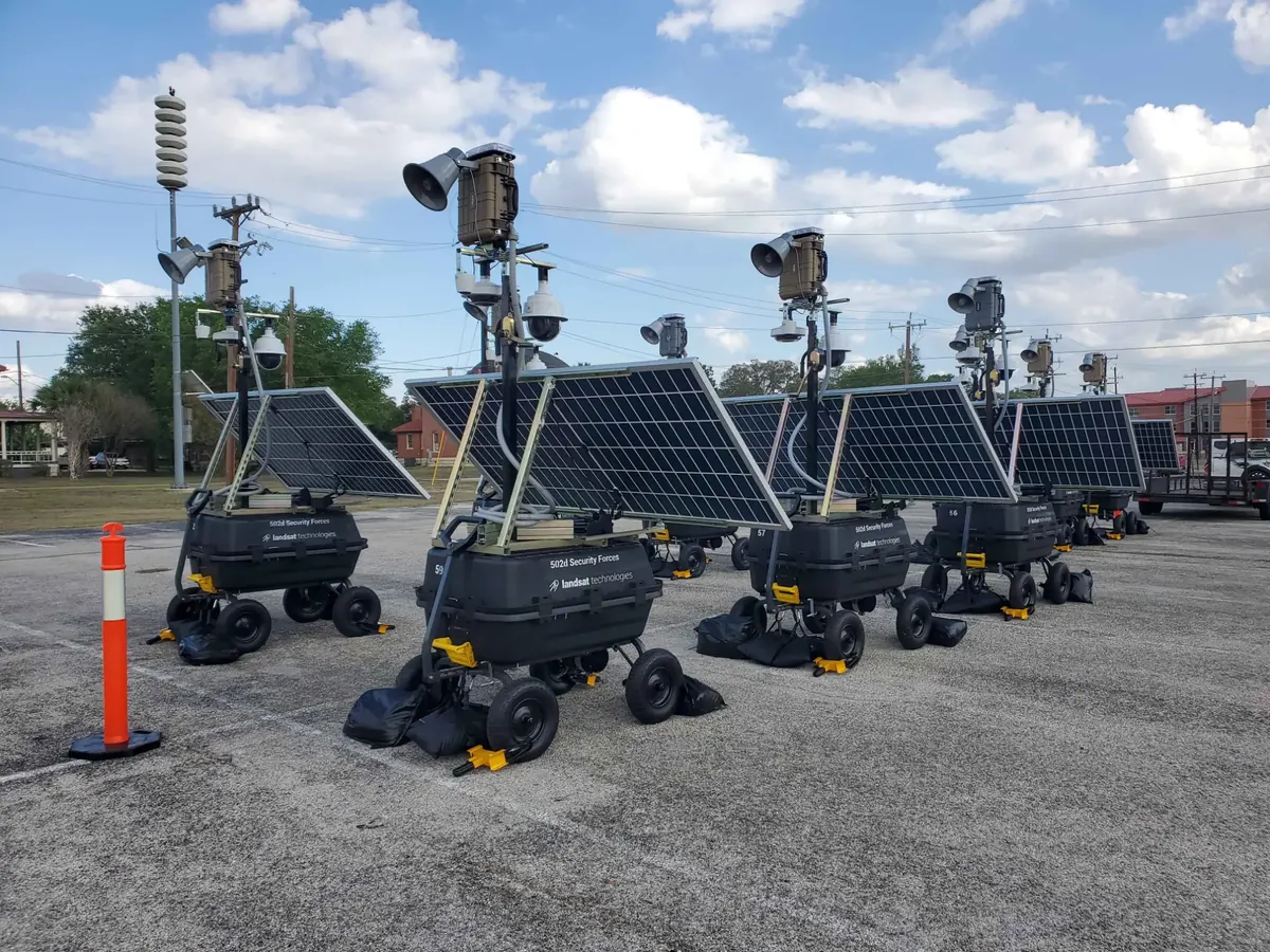 A line of LOBO towers in the government configuration on a base parking lot.