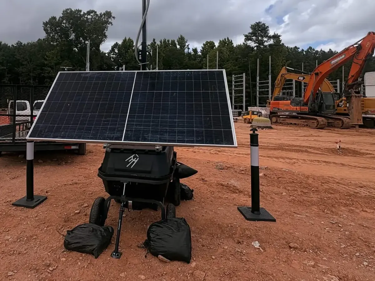 LOBO on a red-dirt construction site, with excavators, pipe and a trailer behind it.