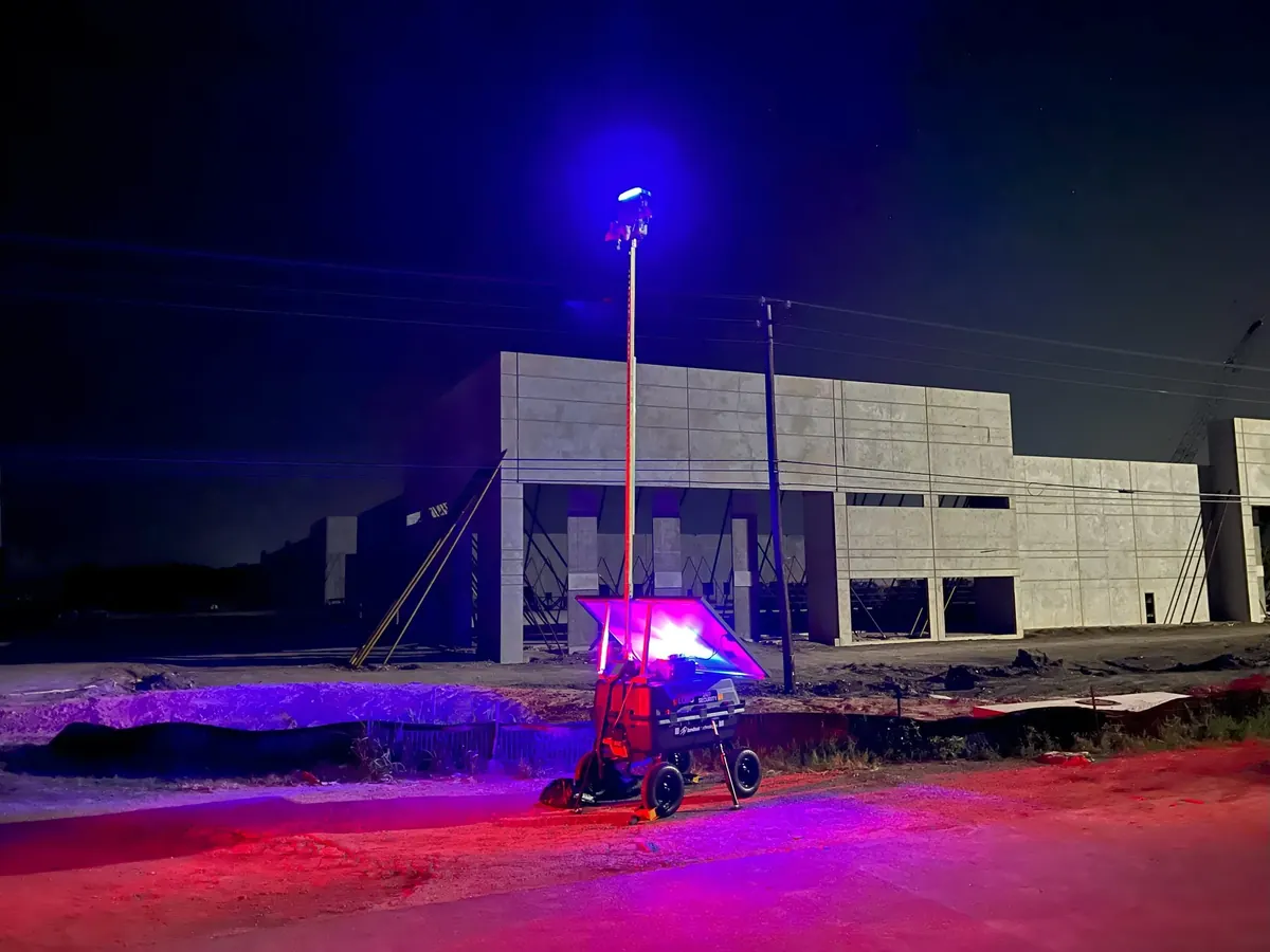 LOBO at night beside a building going up, its blue and red lights on.