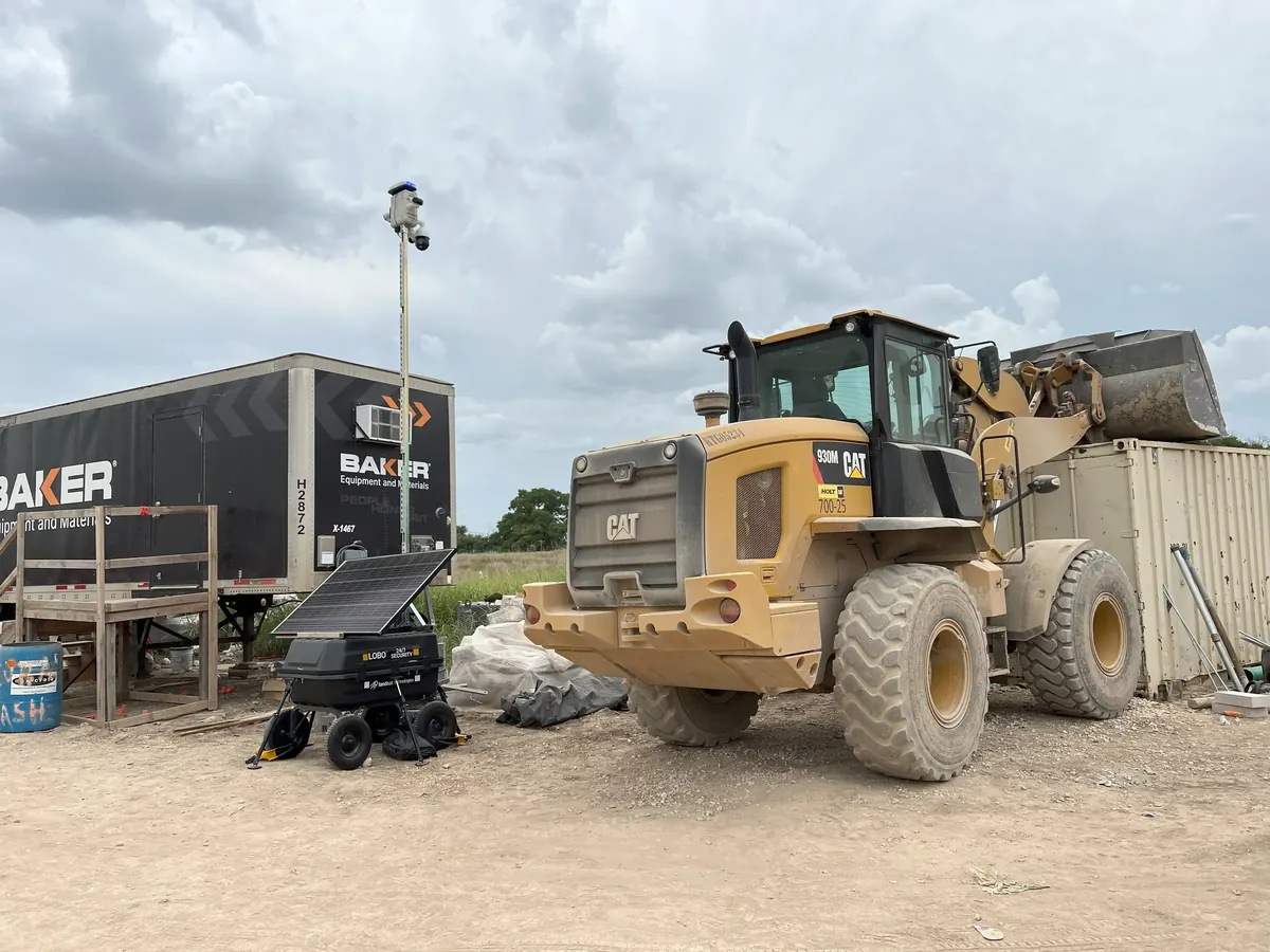 An earlier LOBO on a construction site, beside a wheel loader and a jobsite trailer.