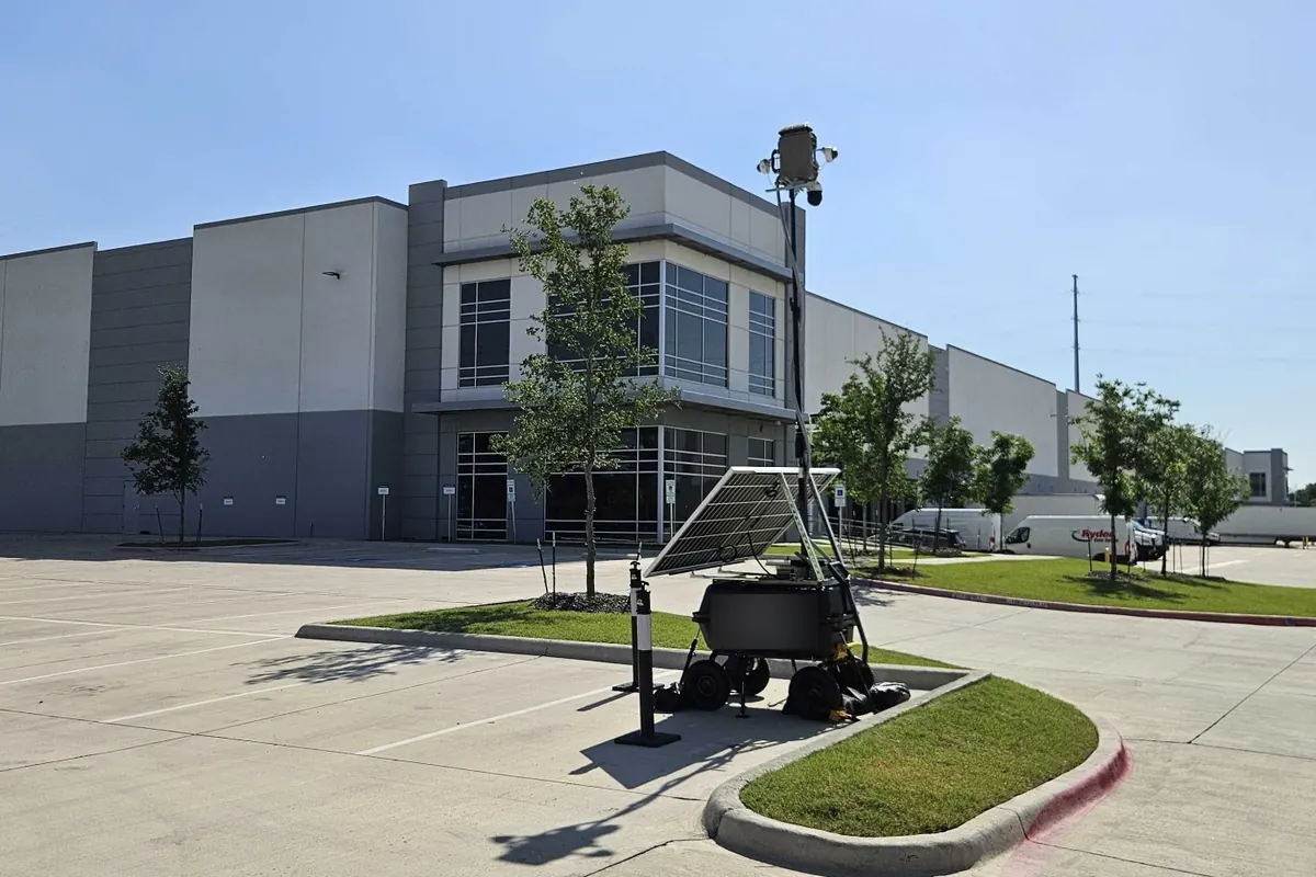 LOBO beside the parking lot at the corner of a large warehouse with a two-story office.