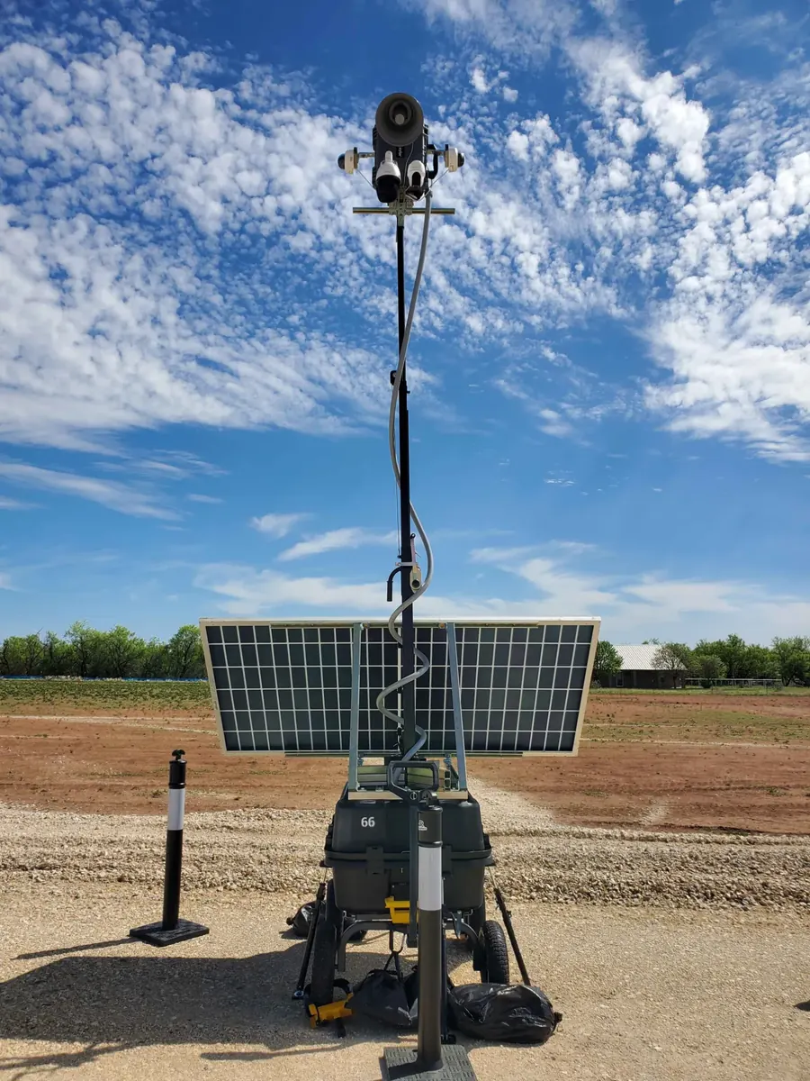 LOBO unit 66 from behind on a laydown yard: horn speaker and cameras at the top of the mast, solar panel, rolling base.