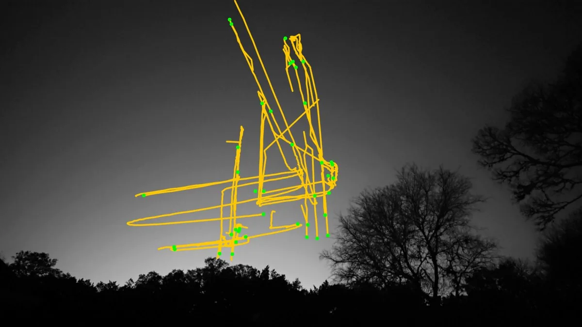 The same night sky with the drone's flight path drawn as amber track lines.